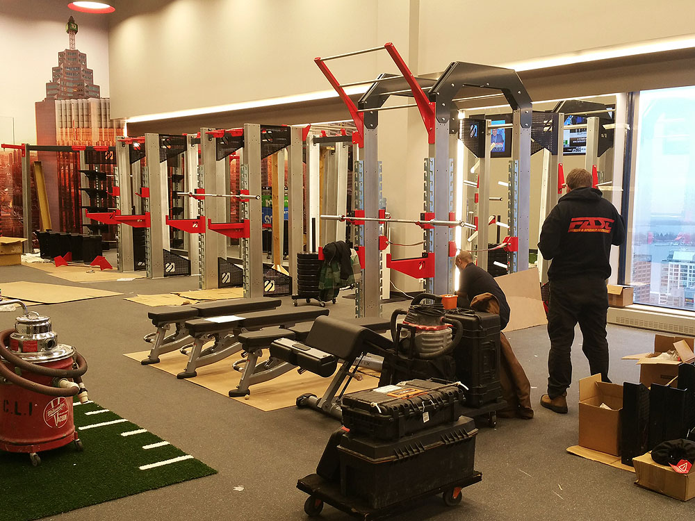 Staff conducting preventative maintenance on gym equipment