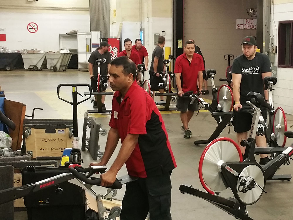 Staff moving comercial spin bike equipment