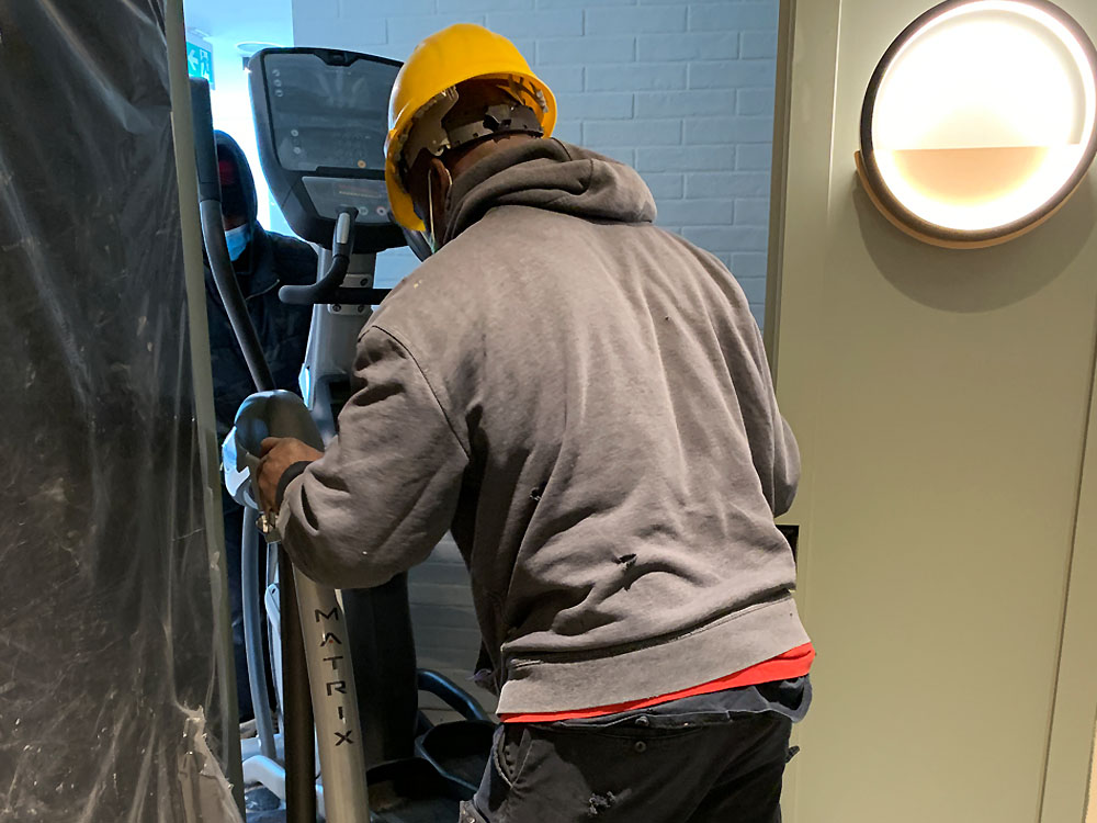 Staff moving commercial stairmaster-through doorway
