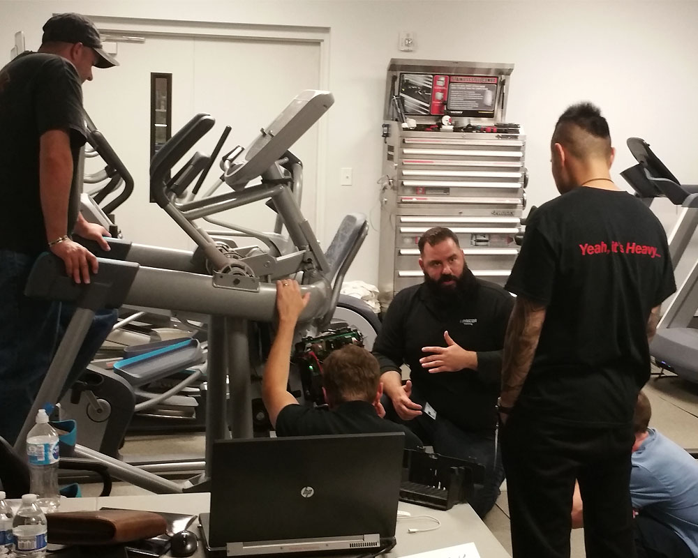 Staff working on commercial elliptical equipment